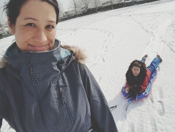 Portrait of smiling young woman standing in snow