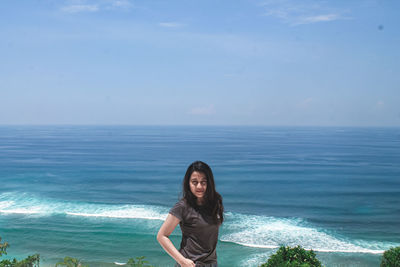 Portrait of young woman against sea against sky