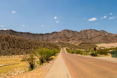 Empty road along landscape and mountains against sky