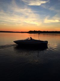 Boat in sea at sunset