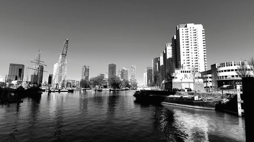 River by buildings against clear sky