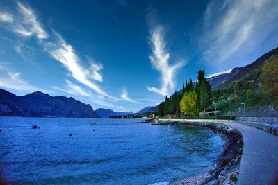 Panoramic view of sea and mountains against blue sky