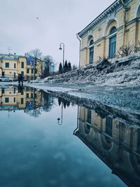 Reflection of buildings in puddle on street