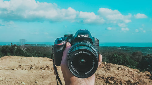Close-up of camera photographing against sky