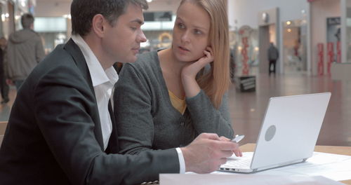 Midsection of woman using mobile phone while sitting on table