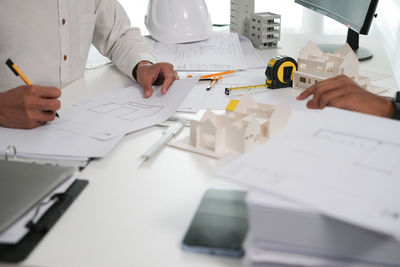 Midsection of architect working on table