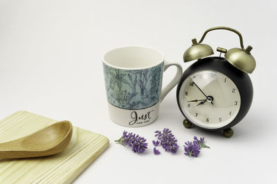 Close-up of clock on table against white background