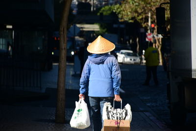 Rear view of woman walking on street in city