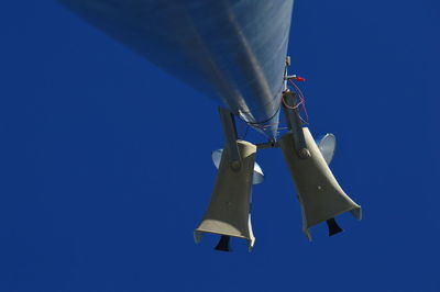 Low angle view of airplane flying against blue sky