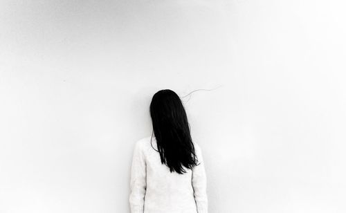 Rear view of woman standing against white background