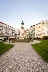 Statue in city against clear sky