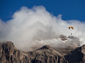 Low angle view of person paragliding over mountain