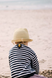 Rear view of person wearing hat on beach