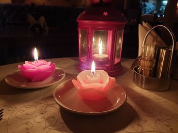 Close-up of illuminated tea light candles on table