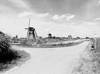 Panoramic view of road amidst field against sky