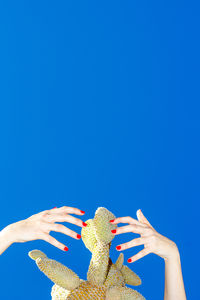 Low angle view of woman against clear blue sky