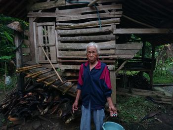 Portrait of smiling woman standing on log