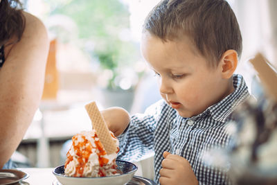 Close-up of boy eating food at home