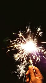 Silhouette of people holding sparkler at night