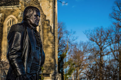 Man standing statue against trees