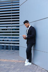 Full length of young man using mobile phone