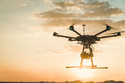 Low angle view of helicopter against sky during sunset