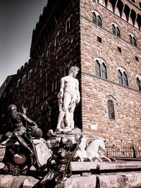 Low angle view of statue against building in city