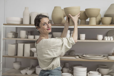 Portrait of young woman standing in kitchen