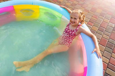 Full length of smiling girl in swimming pool