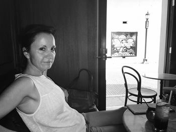 Side view portrait of mature woman at table in cafe