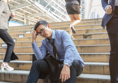 Men sitting on staircase in city