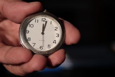 Close-up of hand holding clock