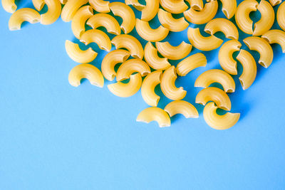 Directly above shot of raw pasta on blue background