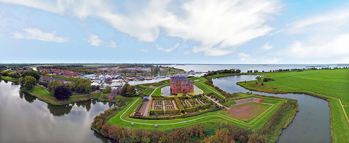 Panoramic view of river and cityscape against sky