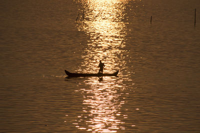 Silhouette man on boat in sea