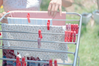 Cropped image of woman drying clothes from laundry rack