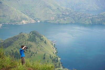 Rear view of man standing on lake