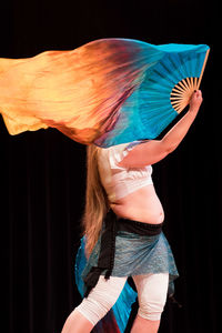 Woman dancing against black background