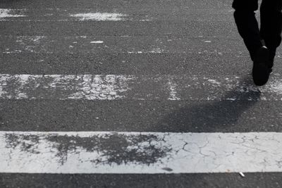 Low section of person walking on road