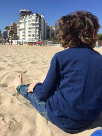 Rear view of couple sitting on beach