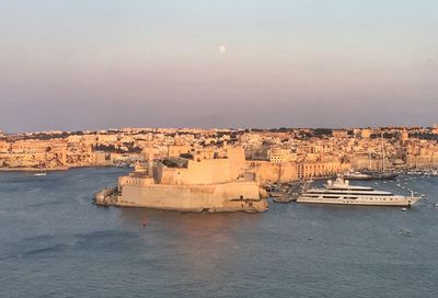 Scenic view of sea and buildings against clear sky