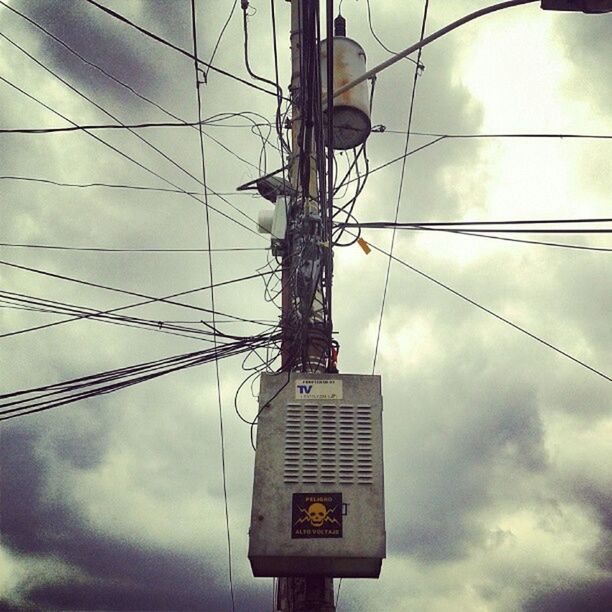 sky, low angle view, power line, cloud - sky, communication, electricity, cable, power supply, cloudy, electricity pylon, connection, technology, text, cloud, western script, fuel and power generation, information sign, pole, guidance, lighting equipment