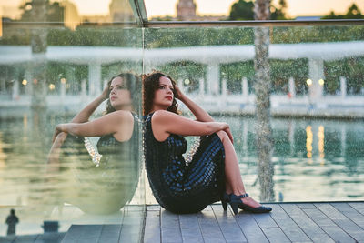 Portrait of young woman sitting in swimming pool