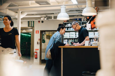 Salesman assisting female customer at hardware store