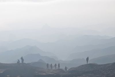 People on mountain against sky