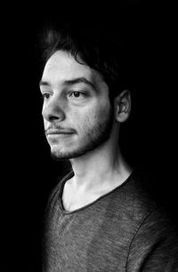 Portrait of young man against black background