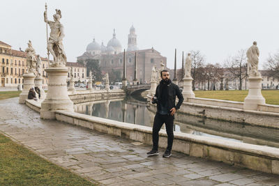 Full length of man standing by canal in city