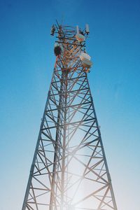 Low angle view of electricity pylon against clear sky