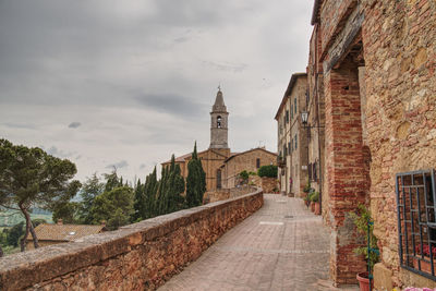 Footpath amidst buildings against sky