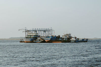 Boats in sea against clear sky